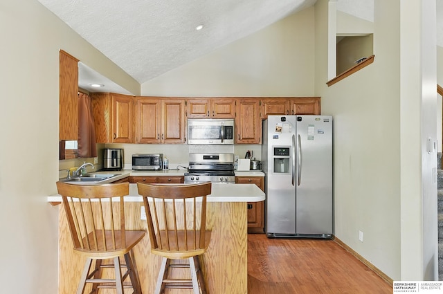 8853 N 82nd Ave, Omaha, NE 68122 - kitchen with stainless steel appliances, a sink, a peninsula, light countertops, and light wood finished floors