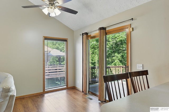 8853 N 82nd Ave, Omaha, NE 68122 - dining room featuring vaulted ceiling, healthy amount of natural light, wood finished floors, a ceiling fan, and a textured ceiling