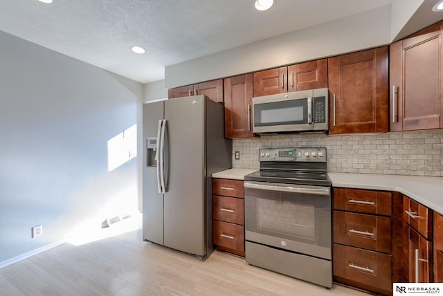 2223 S 161st Cir, Omaha, NE 68130 - kitchen with appliances with stainless steel finishes, light wood-style floors, backsplash, light countertops, and recessed lighting