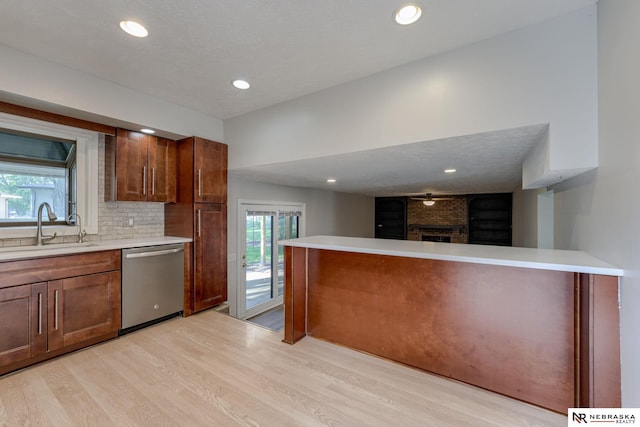 2223 S 161st Cir, Omaha, NE 68130 - kitchen with stainless steel dishwasher, a sink, light wood-type flooring, light countertops, and healthy amount of natural light