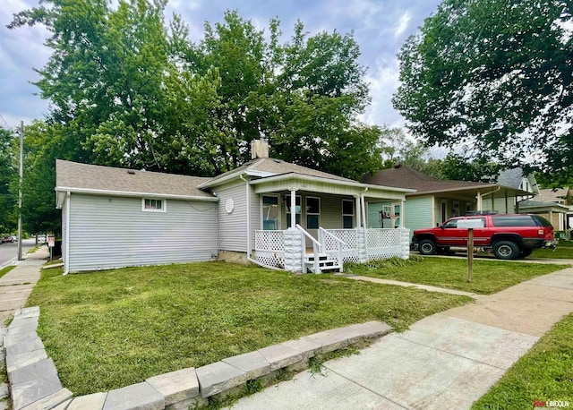 1402 Rose St, Lincoln, NE 68502 - view of front facade featuring a porch, a chimney, and a front yard