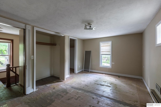 355 N 8th St, Arlington, NE 68002 - unfurnished bedroom featuring a textured ceiling, two closets, and baseboards