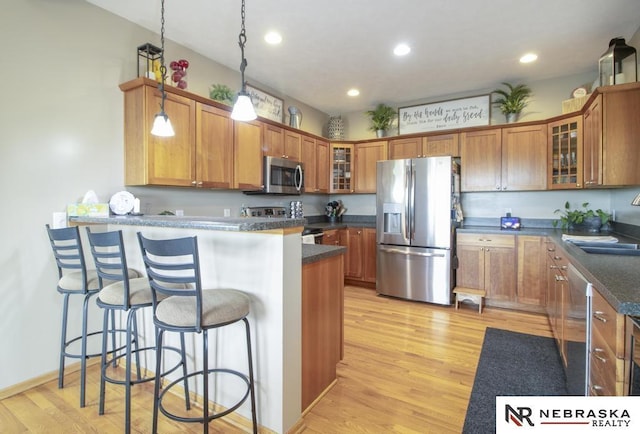 13410 Highlander Pl, Waverly, NE 68462 - kitchen with stainless steel appliances, a peninsula, brown cabinetry, and recessed lighting