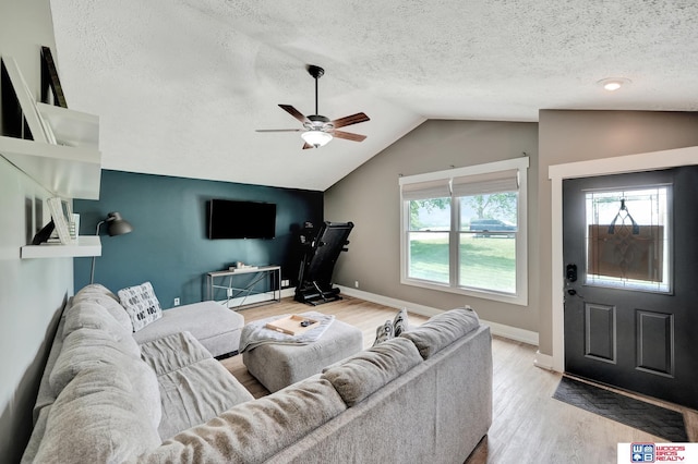 631 Overlook Ln, Beatrice, NE 68310 - living room with wood finished floors, lofted ceiling, ceiling fan, a textured ceiling, and baseboards
