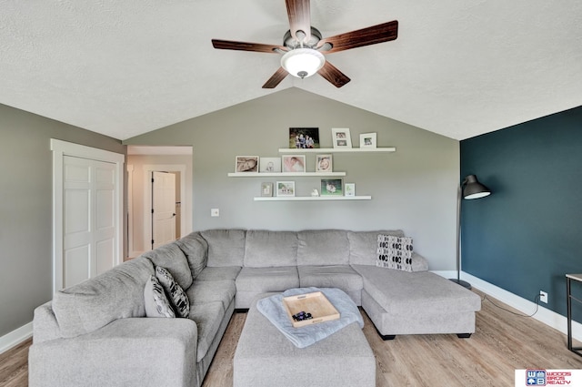 631 Overlook Ln, Beatrice, NE 68310 - living area featuring light wood-style flooring, a ceiling fan, vaulted ceiling, baseboards, and a textured ceiling