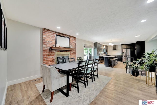 631 Overlook Ln, Beatrice, NE 68310 - dining space featuring light wood finished floors, recessed lighting, baseboards, and a fireplace