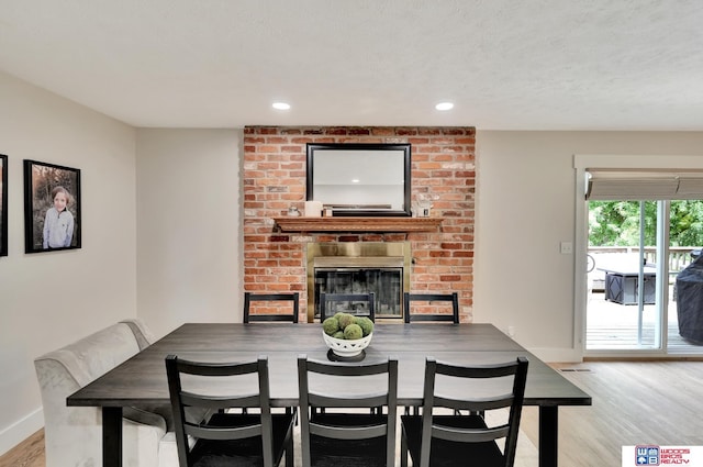 631 Overlook Ln, Beatrice, NE 68310 - dining area featuring light wood-style floors, a fireplace, baseboards, and recessed lighting
