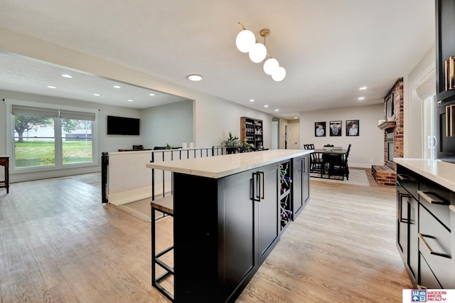 631 Overlook Ln, Beatrice, NE 68310 - kitchen with a kitchen bar, light wood-style floors, light countertops, a center island, and recessed lighting