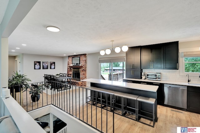 631 Overlook Ln, Beatrice, NE 68310 - kitchen featuring appliances with stainless steel finishes, light wood finished floors, plenty of natural light, light countertops, and recessed lighting