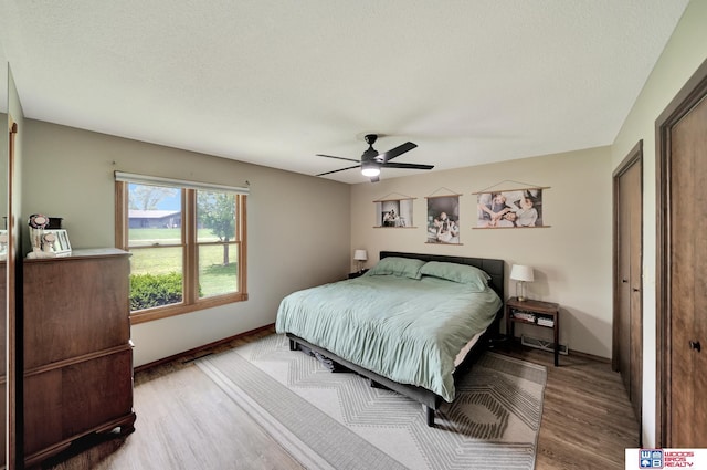 631 Overlook Ln, Beatrice, NE 68310 - bedroom with wood finished floors, baseboards, ceiling fan, and a textured ceiling