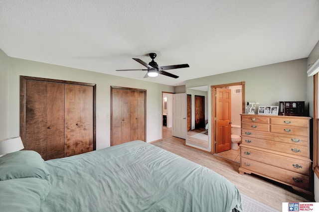 631 Overlook Ln, Beatrice, NE 68310 - bedroom featuring light wood finished floors, multiple closets, a ceiling fan, and a textured ceiling
