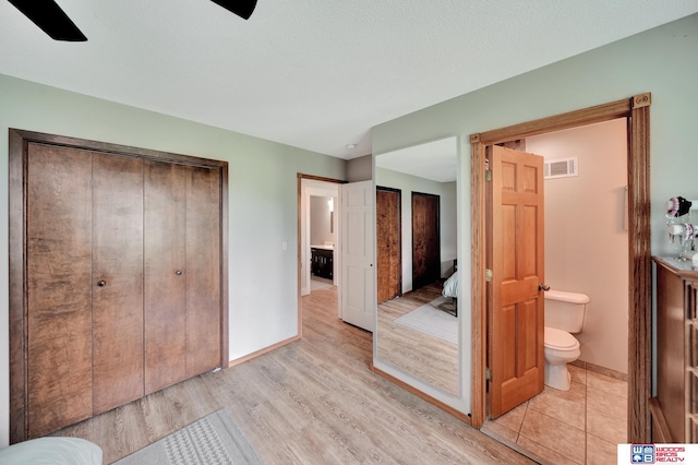 631 Overlook Ln, Beatrice, NE 68310 - unfurnished bedroom featuring light wood-style flooring, baseboards, connected bathroom, and a ceiling fan