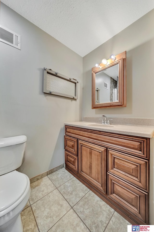 631 Overlook Ln, Beatrice, NE 68310 - half bath with toilet, vanity, tile patterned floors, baseboards, and a textured ceiling