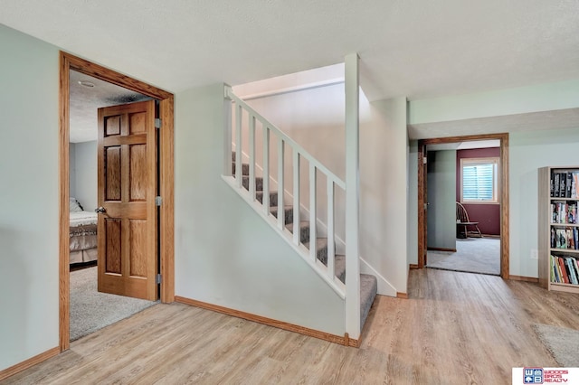 631 Overlook Ln, Beatrice, NE 68310 - stairway with wood finished floors, baseboards, and a textured ceiling