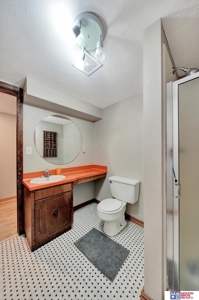 631 Overlook Ln, Beatrice, NE 68310 - bathroom featuring a stall shower, vanity, toilet, and baseboards