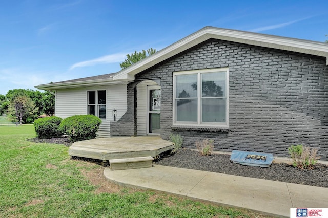 631 Overlook Ln, Beatrice, NE 68310 - view of front of property featuring a front yard, a deck, and brick siding