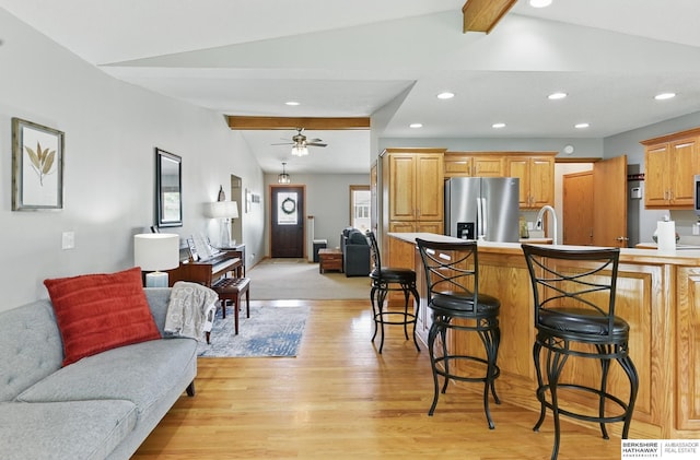 2442 E 2nd St, Fremont, NE 68025 - kitchen featuring stainless steel fridge with ice dispenser, open floor plan, a breakfast bar, light wood finished floors, and a ceiling fan