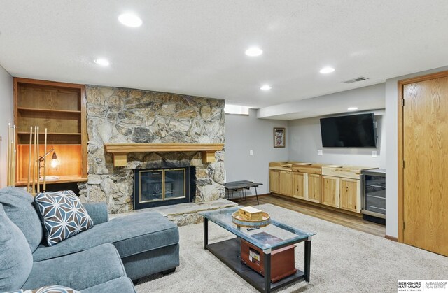 2442 E 2nd St, Fremont, NE 68025 - living area featuring wine cooler, recessed lighting, a stone fireplace, wood finished floors, and baseboards