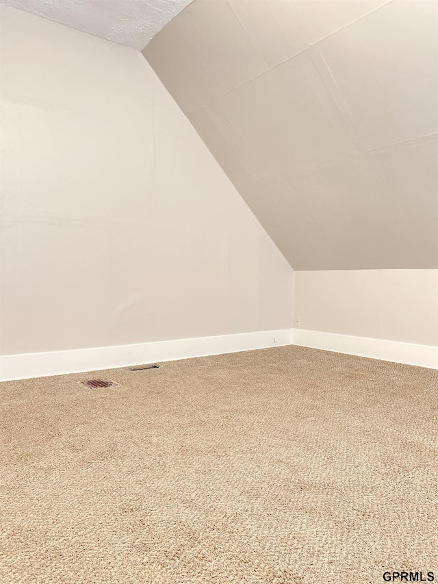 3719 X St, Omaha, NE 68107 - additional living space with carpet floors, vaulted ceiling, and baseboards