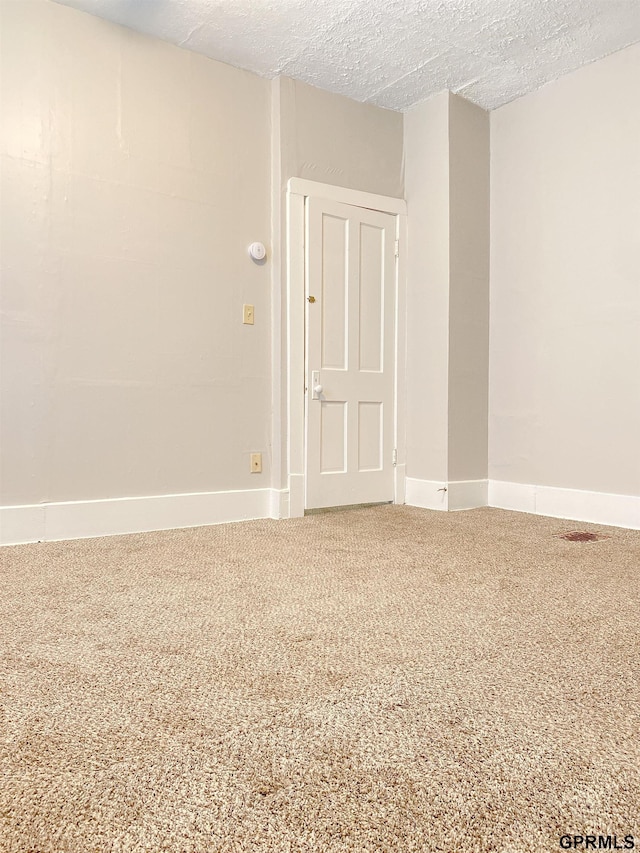 3719 X St, Omaha, NE 68107 - empty room featuring a textured ceiling, baseboards, and carpet
