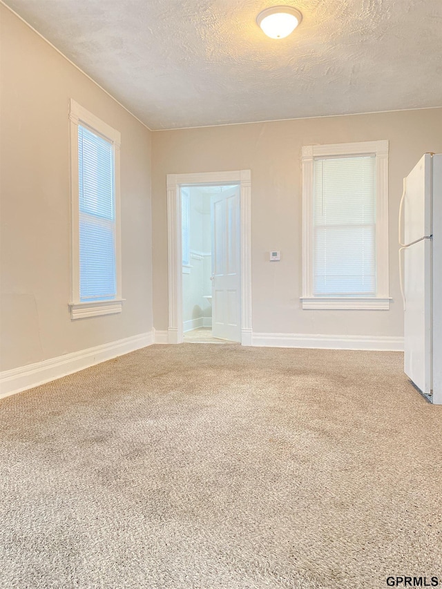 3719 X St, Omaha, NE 68107 - spare room with carpet flooring, a textured ceiling, and baseboards