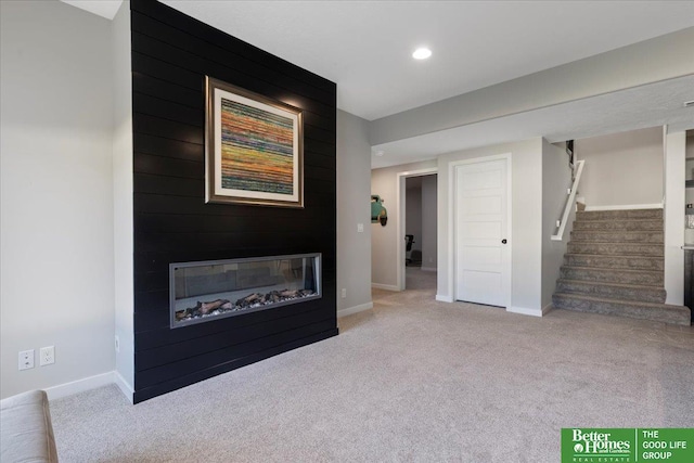 6518 S 208th Ave, Elkhorn, NE 68022 - unfurnished living room featuring carpet flooring, stairway, baseboards, a glass covered fireplace, and recessed lighting
