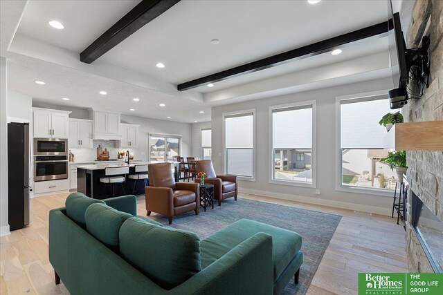 6518 S 208th Ave, Elkhorn, NE 68022 - living room featuring beamed ceiling, a glass covered fireplace, light wood-type flooring, and recessed lighting