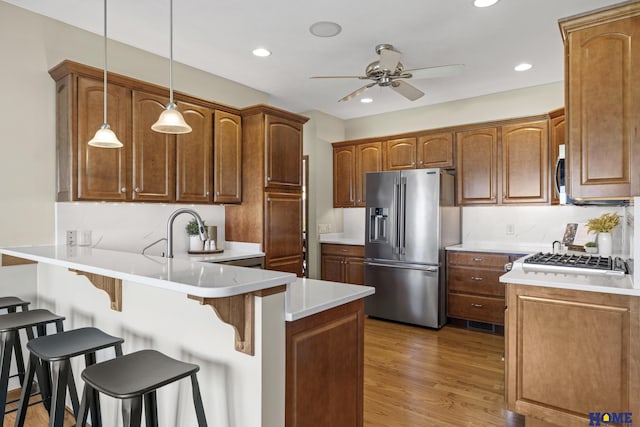 6920 NW 3rd St, Lincoln, NE 68521 - kitchen featuring appliances with stainless steel finishes, a peninsula, ceiling fan, a sink, and a kitchen bar