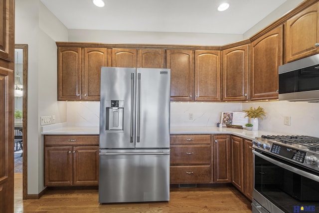 6920 NW 3rd St, Lincoln, NE 68521 - kitchen with appliances with stainless steel finishes, dark wood-style floors, light countertops, decorative backsplash, and recessed lighting