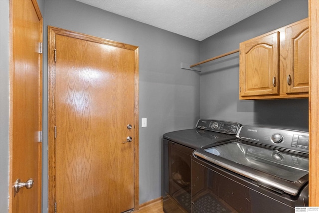 15212 Emmet St, Omaha, NE 68116 - washroom with cabinet space, washer and clothes dryer, a textured ceiling, and wood finished floors
