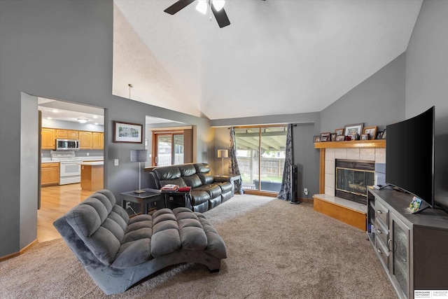 15212 Emmet St, Omaha, NE 68116 - living room featuring a ceiling fan, a tile fireplace, light carpet, high vaulted ceiling, and baseboards