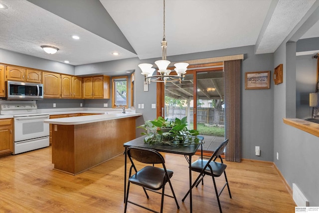 15212 Emmet St, Omaha, NE 68116 - kitchen featuring electric stove, stainless steel microwave, light countertops, a chandelier, and light wood-type flooring