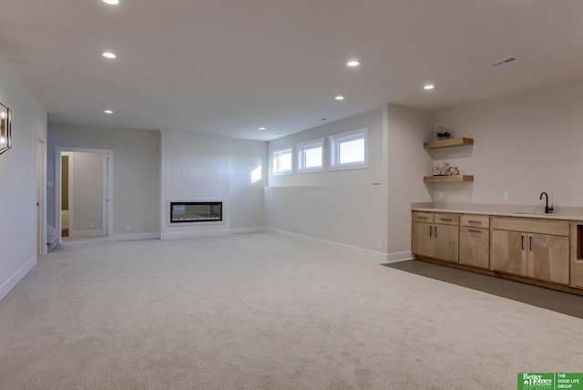 21056 Joseph St, Elkhorn, NE 68022 - unfurnished living room featuring recessed lighting, a sink, a large fireplace, light carpet, and baseboards