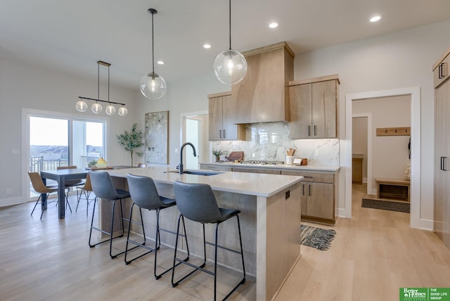 21056 Joseph St, Elkhorn, NE 68022 - kitchen with a sink, a breakfast bar, light brown cabinetry, light countertops, and recessed lighting