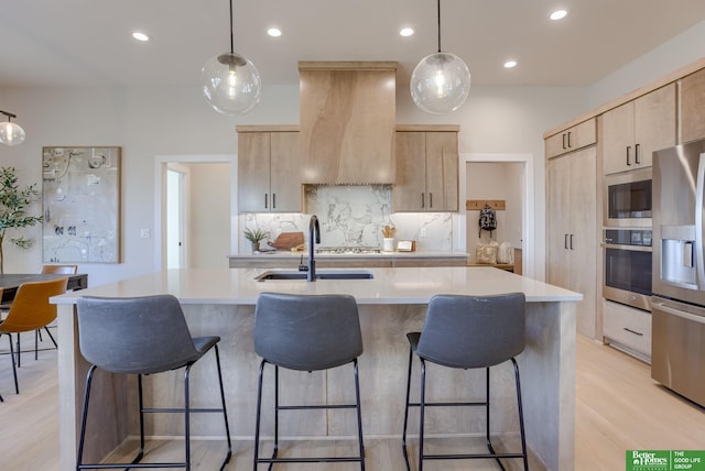 21056 Joseph St, Elkhorn, NE 68022 - kitchen featuring stainless steel appliances, light brown cabinets, range hood, light countertops, and recessed lighting