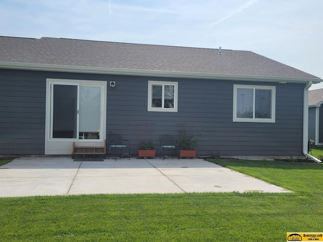 843 N 26th St, Beatrice, NE 68310 - rear view of property featuring a yard, a patio, and a shingled roof
