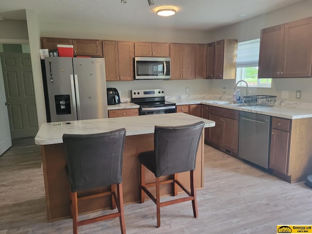 843 N 26th St, Beatrice, NE 68310 - kitchen featuring stainless steel appliances, light wood-style flooring, a kitchen island, and a breakfast bar