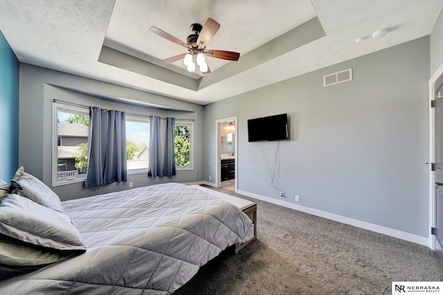 905 Chicory Ln, Hickman, NE 68372 - carpeted bedroom with baseboards, a tray ceiling, and connected bathroom