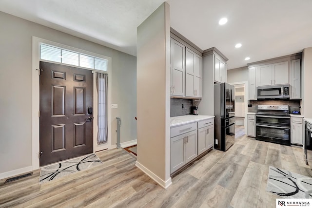 905 Chicory Ln, Hickman, NE 68372 - kitchen featuring double oven range, stainless steel microwave, freestanding refrigerator, gray cabinets, and recessed lighting