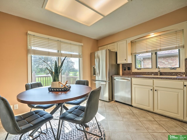 6212 Oak Hills Plz, Omaha, NE 68137 - kitchen featuring appliances with stainless steel finishes, a sink, dark countertops, and healthy amount of natural light
