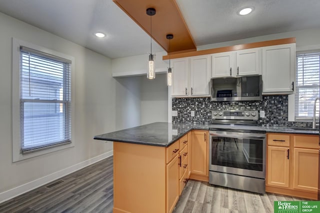 2864 Spaulding St, Omaha, NE 68111 - kitchen featuring appliances with stainless steel finishes, a peninsula, tasteful backsplash, light wood-type flooring, and recessed lighting