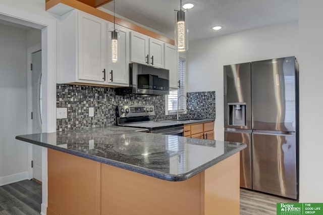 2864 Spaulding St, Omaha, NE 68111 - kitchen featuring stainless steel appliances, wood finished floors, a peninsula, tasteful backsplash, and recessed lighting