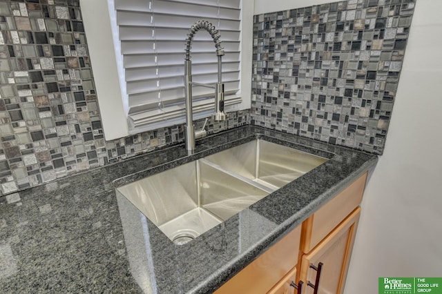 2864 Spaulding St, Omaha, NE 68111 - kitchen view of a sink, backsplash, brown cabinetry, and dark stone counters