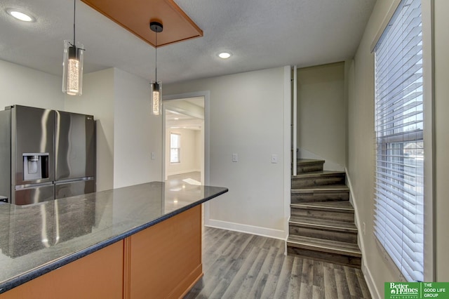 2864 Spaulding St, Omaha, NE 68111 - kitchen with stainless steel fridge, baseboards, wood finished floors, recessed lighting, and dark stone counters