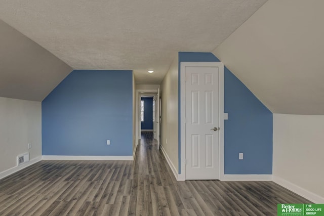 2864 Spaulding St, Omaha, NE 68111 - bonus room with wood finished floors, vaulted ceiling, a textured ceiling, and baseboards