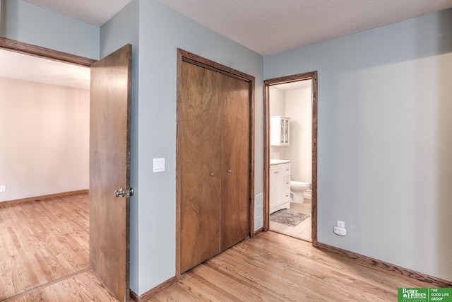 830 N 78th St, Omaha, NE 68114 - unfurnished bedroom featuring light wood-style floors, a closet, baseboards, and connected bathroom