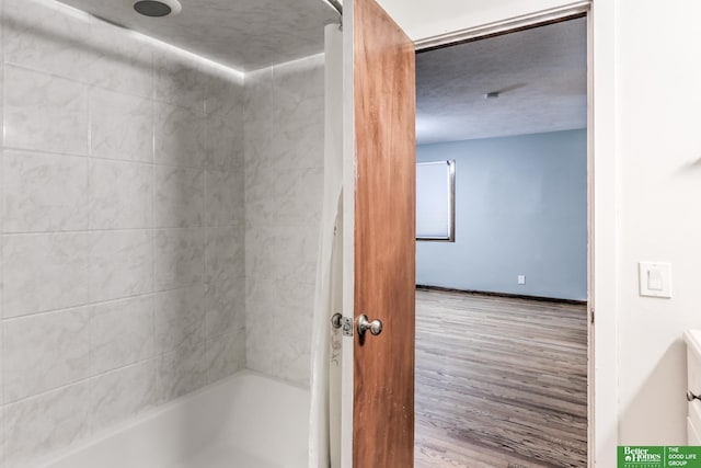 830 N 78th St, Omaha, NE 68114 - bathroom with wood finished floors, tub / shower combination, and baseboards