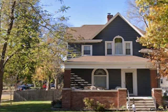 1205 N Broad St, Fremont, NE 68025 - view of front of home featuring a porch, a chimney, stairway, and roof with shingles