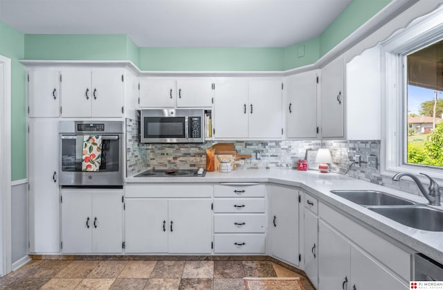 1439 S 123rd St, Omaha, NE 68144 - kitchen with appliances with stainless steel finishes, a sink, tasteful backsplash, and white cabinetry