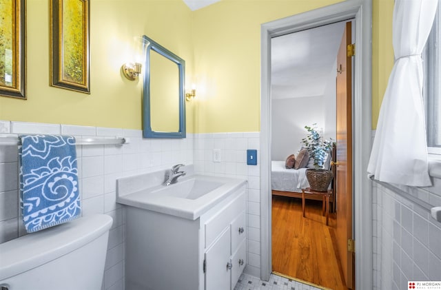 1439 S 123rd St, Omaha, NE 68144 - bathroom with tile walls, vanity, toilet, a wainscoted wall, and ensuite bathroom